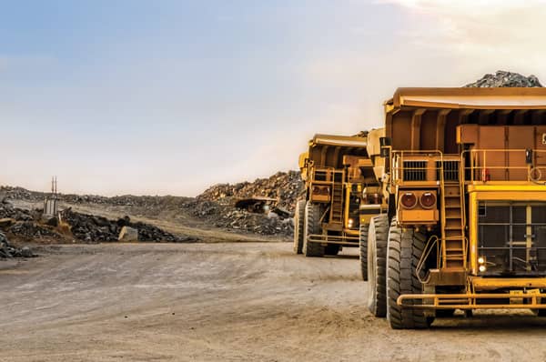 dump-trucks-carrying-ore-sunset